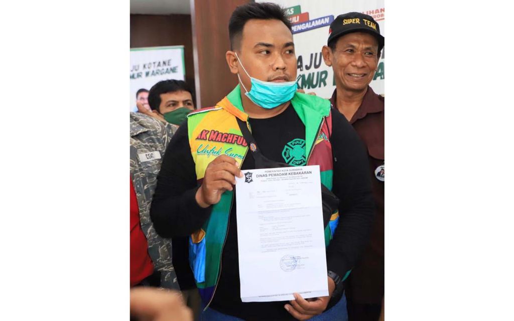 Fahrul Suganda, pegawai outsourcing Dinas Pemadam Kebakaran (PMK) Surabaya menunjukkan surat pemecatan dirinya