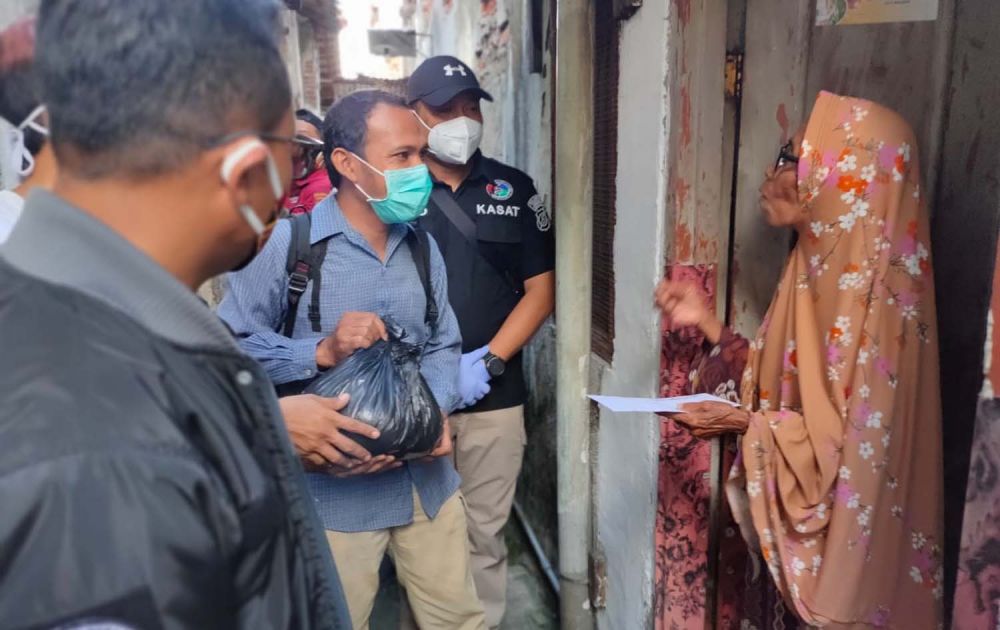 Ketua Pokja Wartawan Polrestabes Surabaya Falentinus Hartayan bersama Kasat Resnarkoba AKBP Memo Ardian saat memberikan bantuan paket sembako ke warga Bubutan