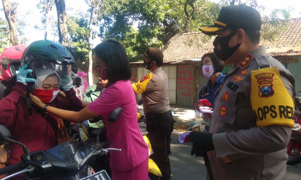 Kapolres Mojokerto AKBP Dony Alexander ikut membagikan masker merah putih