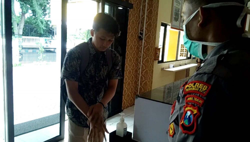 Salah satu pengunjung di Mapolres Probolinggo Kota diminta untuk mencuci tangan pakai hand sanitizer yang sudah disediakan