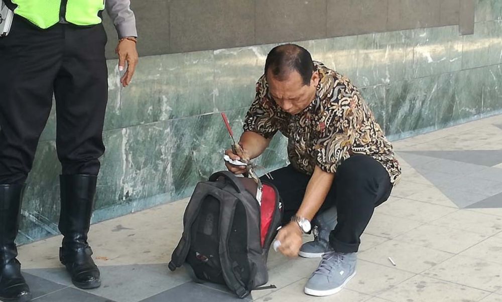 Polisi memeriksa tas milik pria misterius yang kabur dari Bank Mandiri, Jalan Kembang Jepun, Surabaya