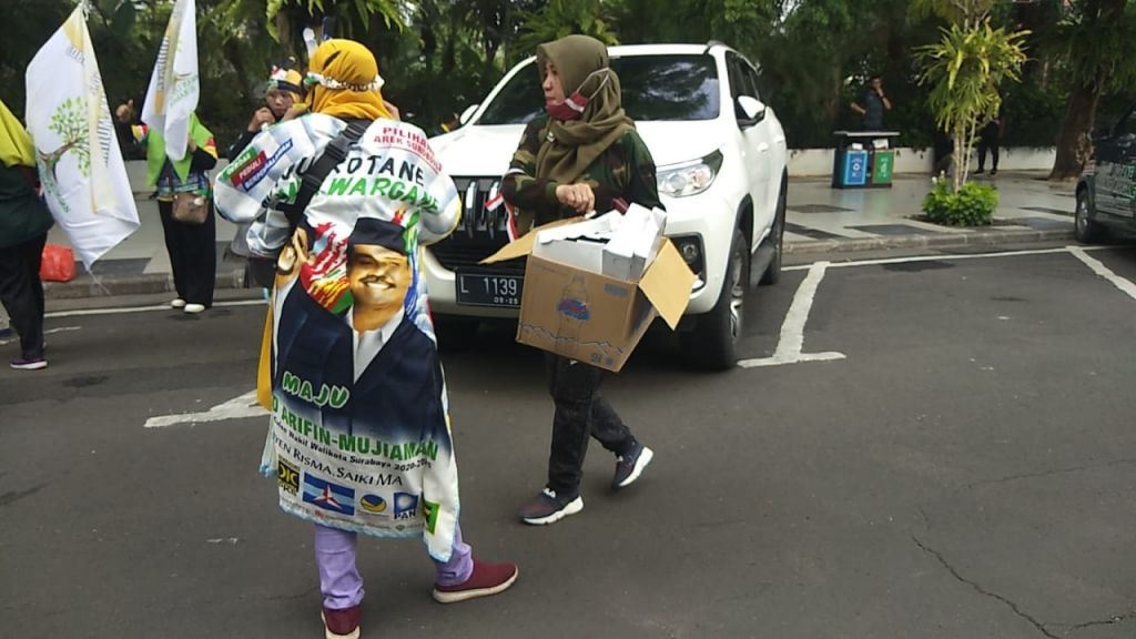 Peserta pendukung Machfud Arifin-Mujiaman membersihkan sampah di Jalan Sedap Malam, Surabaya