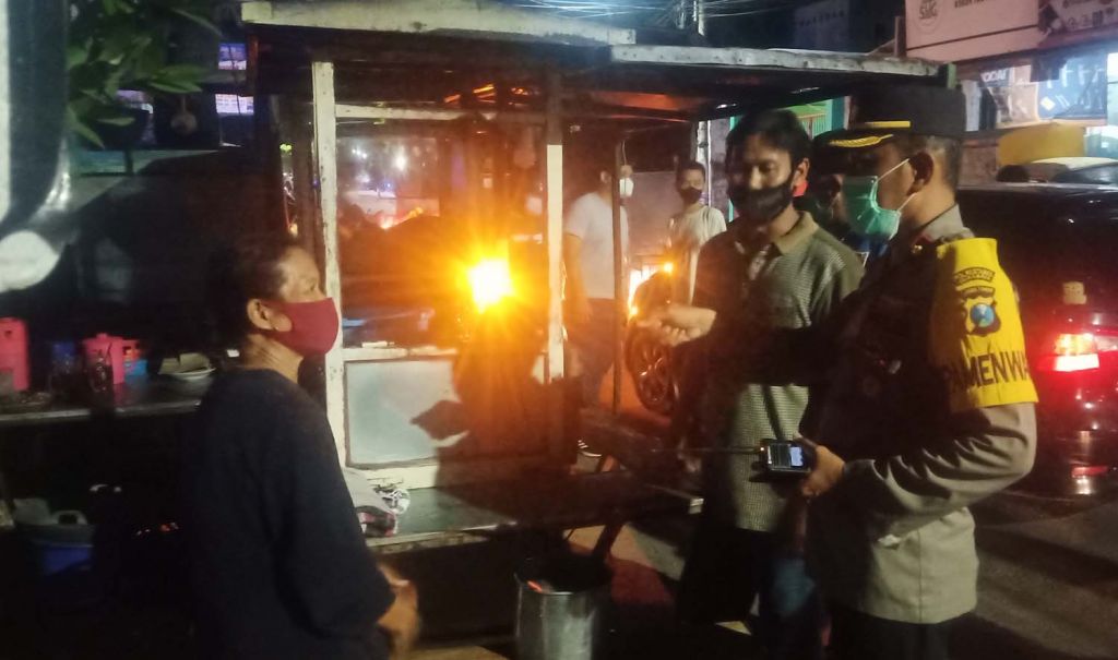 Petugas gabungan di Surabaya menindak salah satu pedagang yang melanggar PPKM Darurat