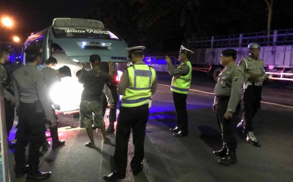 Polisi memeriksa barang bawaan di dalam mobil