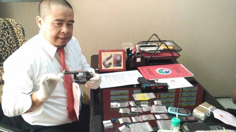 Kasat Resnarkoba Polres Pasuruan, AKP Nanang Sugiyono menunjukkan pistol sang bandar