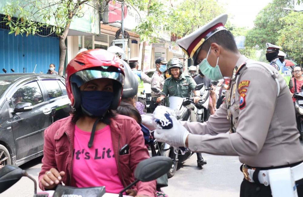 Kasatlantas Polres Tulungagung AKP Aristianto Budi Sutrisno memberikan masker gratis untuk salah satu warga