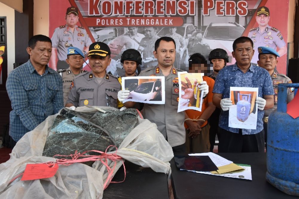 Kapolres Trenggalek AKBP Jean Calvijn Simanjuntak menunjukkan foto perusakan mobil dan penganiayaan yang dilakukan tersangka
