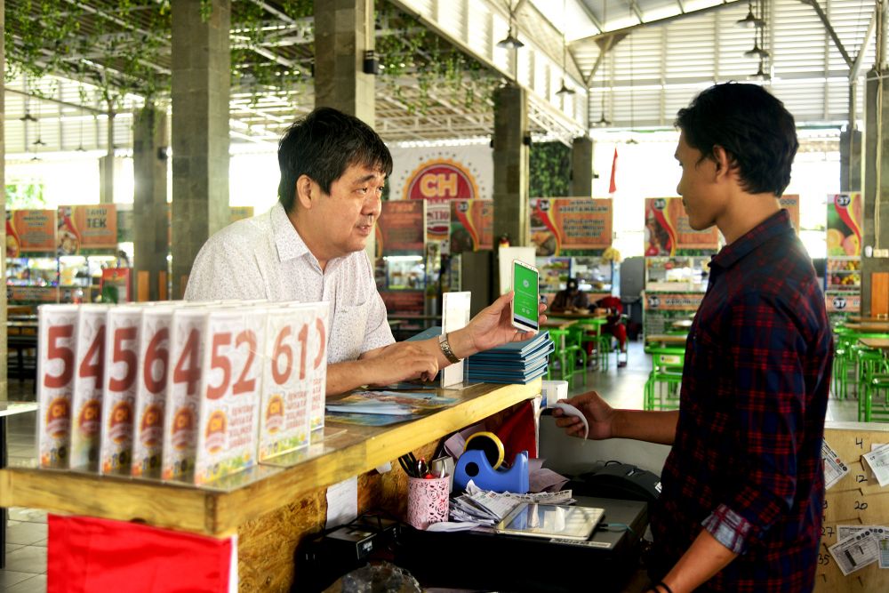 Salah seorang pengunjung bertransaksi secara non-tunai di SWK Convention Hall Jalan Arief Rahman Hakim, Surabaya