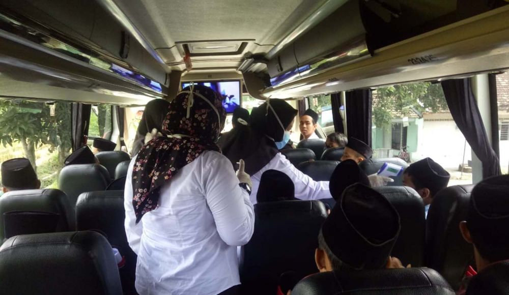 Para santri di-screening menggunakan thermo gun