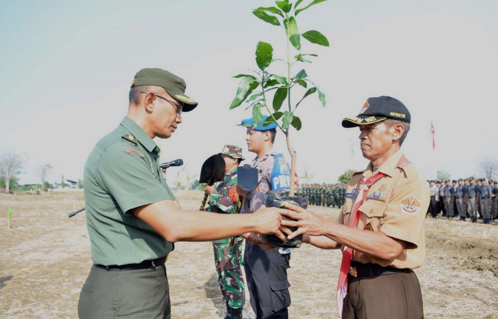 Salah satu petinggi TNI memberikan pohon yang akan ditanam kepada anggota Pramuka