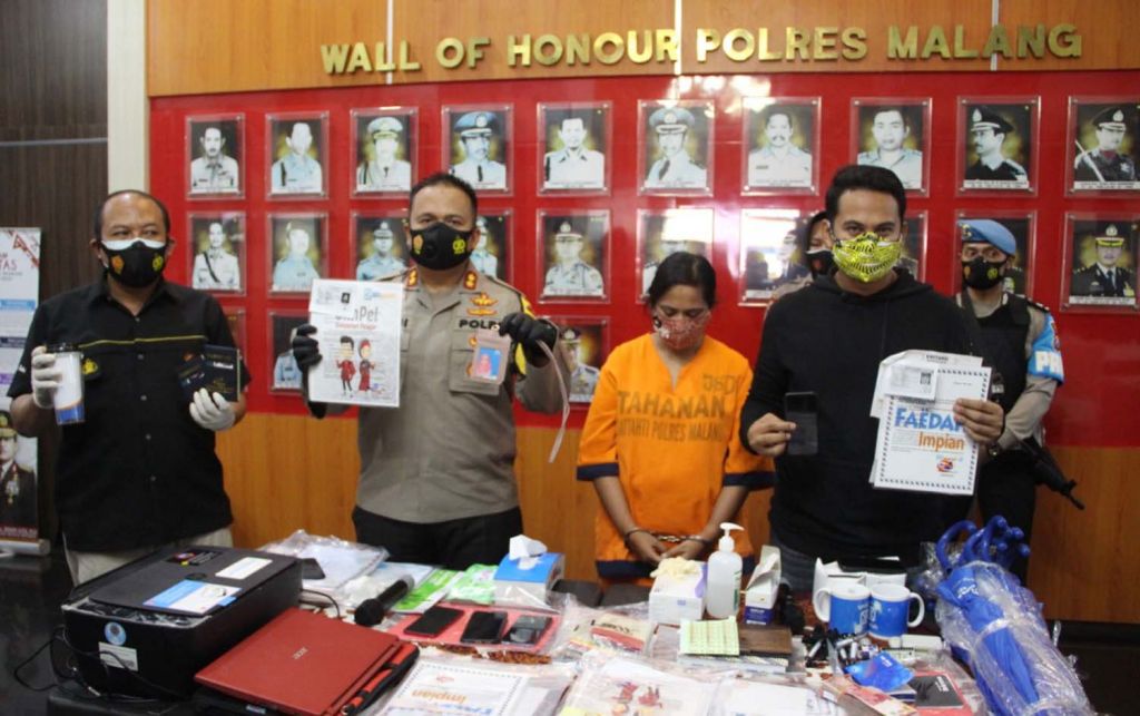 Kapolres Malang, AKBP Hendri Umar menunjukkan tersangka investasi bodong dan sederet barang bukti