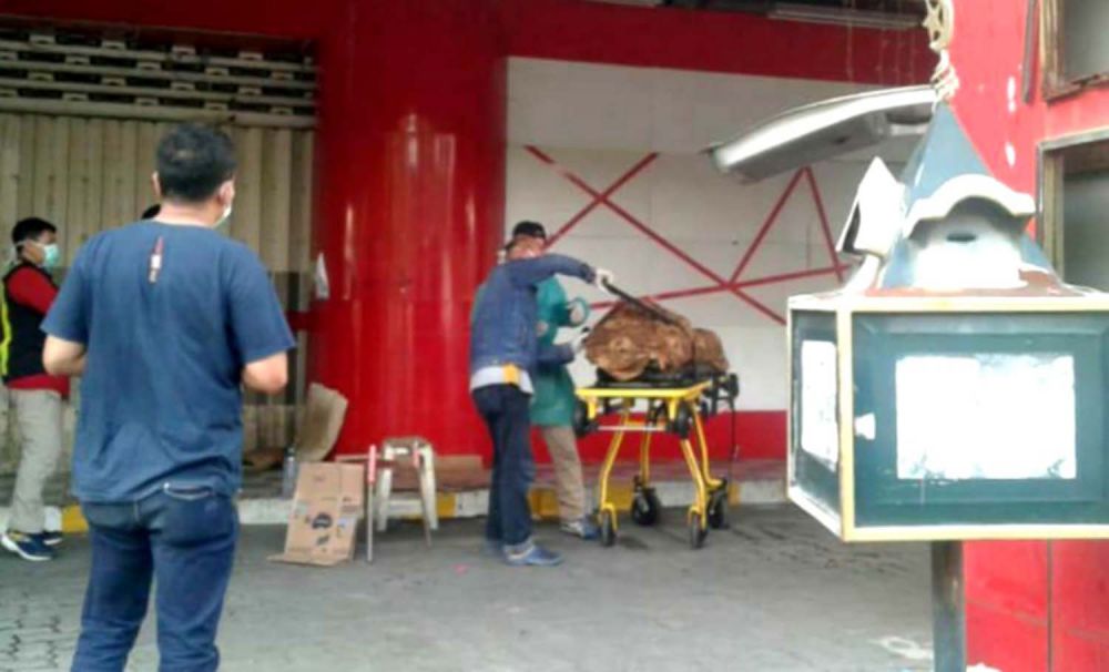 Proses evakuasi jasad pria yang ditemukan tewas di depan toko swalayan di Gresik