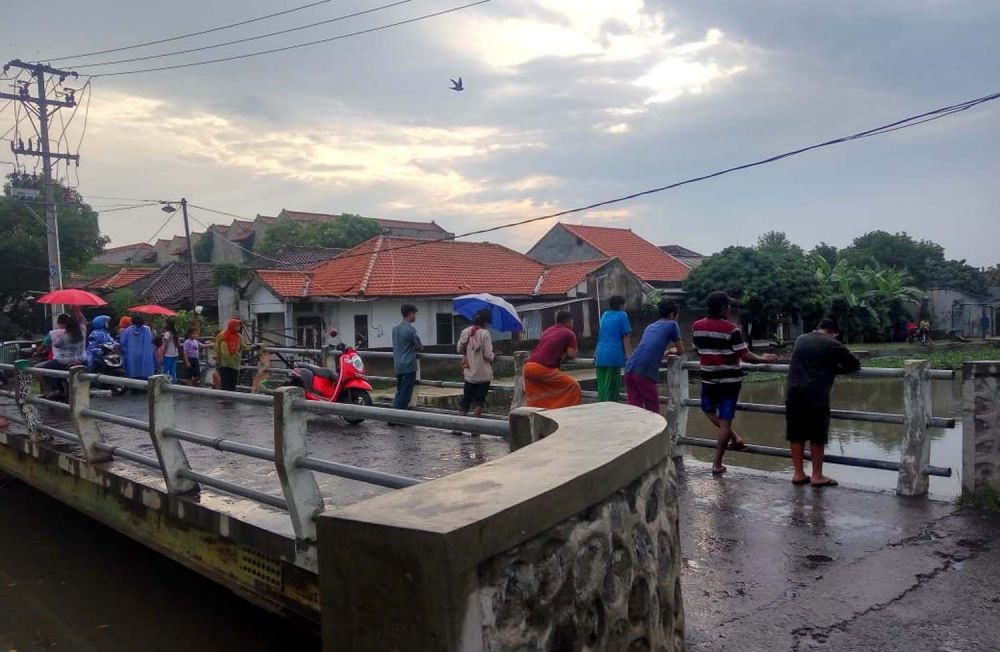 Warga melihat proses pencarian tiga anak yang dilaporkan hilang tenggelam di Sungai Pucang, Sidoarjo