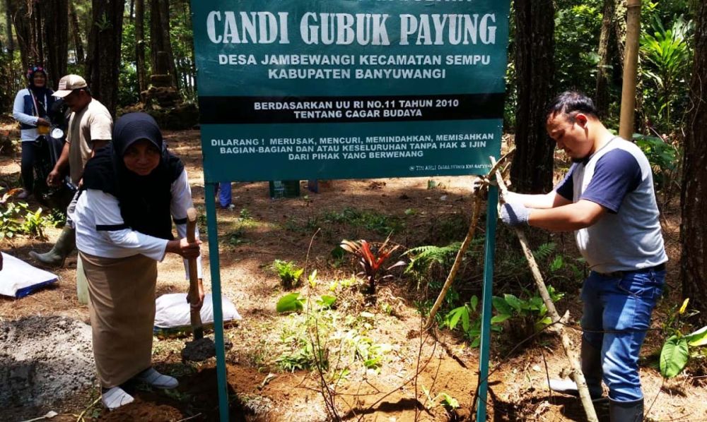 Anggota Tim Ahli Cagar Budaya (TACB) Banyuwangi memasang papan peringatan di Situs Candi Gumuk Payung. kawasan Perhutani Desa Jambewangi. Kecamatan Sempu