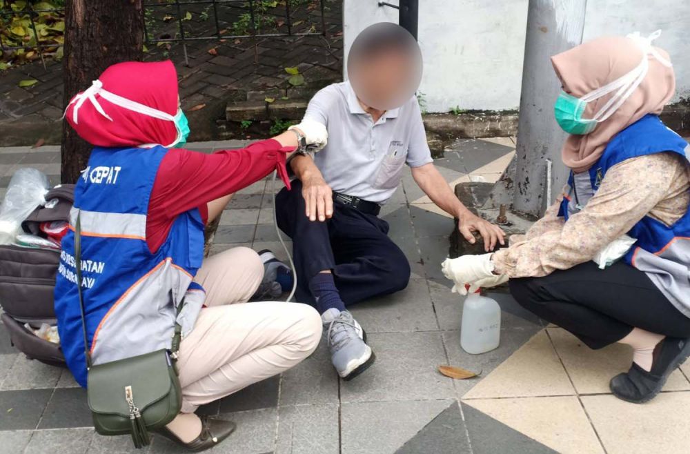 Petugas medis menolong pria yang terjatuh di daerah Bubutan, Surabaya