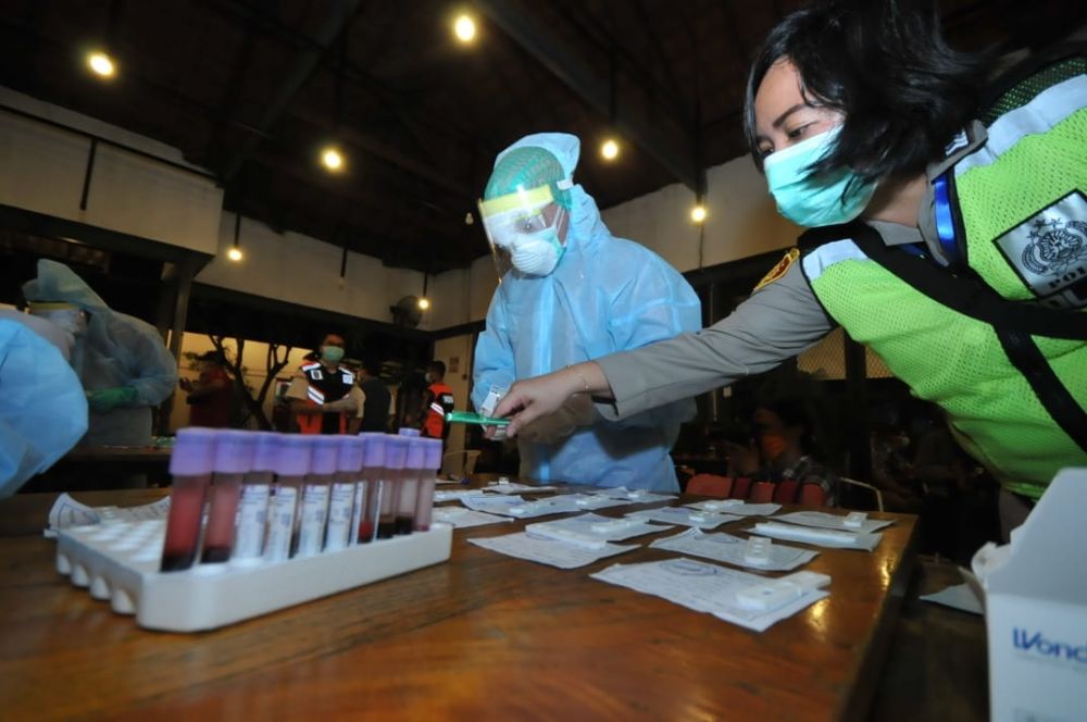 Pengunjung di Caffe Rolag, Jalan Khairil Anwar, Surabaya satu per satu menjalani rapid test