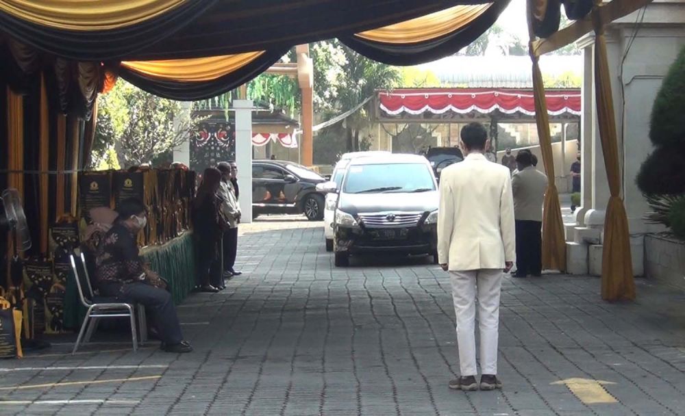 Para wisudawan menunggu giliran di atas kendaraannya masing-masing dalam wisuda drive thru UWK Surabaya