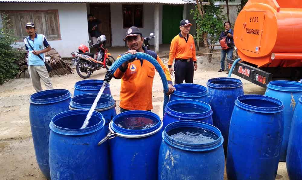 Petugas BPBD Tulungagung mengisi tong dengan air bersih