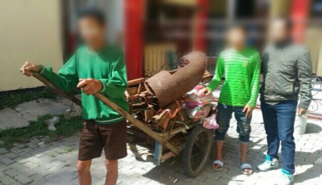 Bapak-anak bersama besi tua satu gerobak yang dicurinya di Kenpark Surabaya.