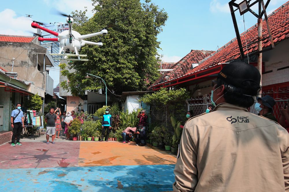 Penggunaan drone untuk menyemprot disinfektan di kampung dan jalanan di Surabaya