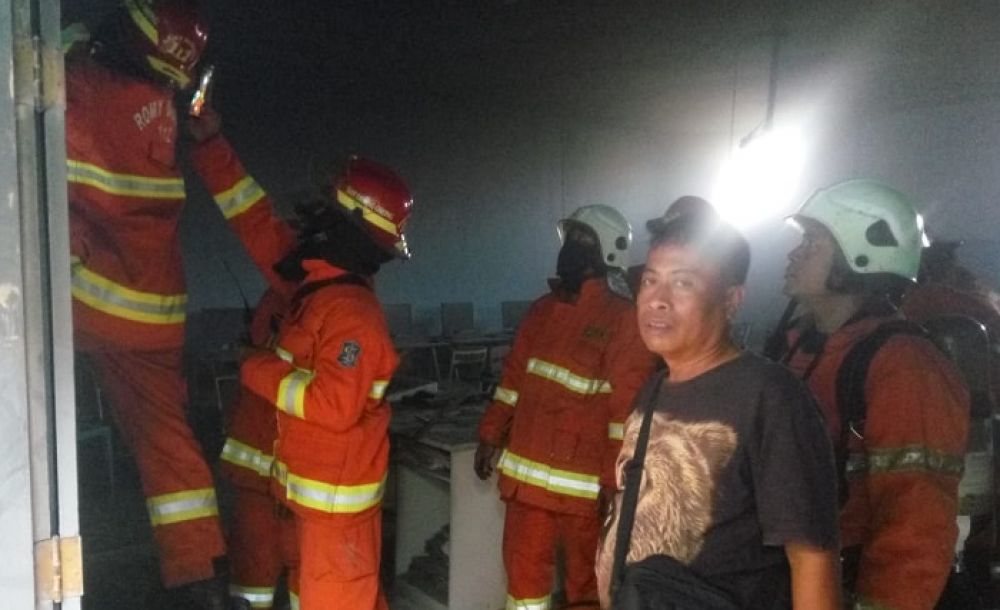 Petugas memadamkam api di SMPN 32 Surabaya