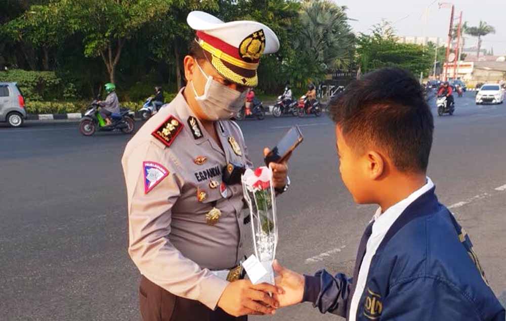 Seorang bocah memberikan bunga kepada polisi