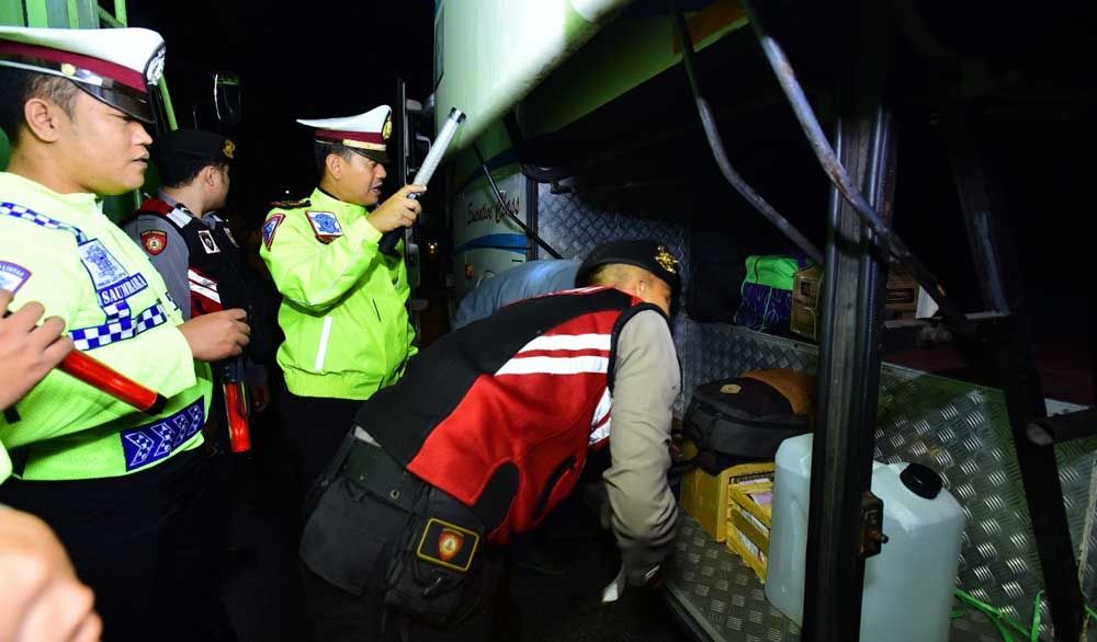Polisi memeriksa barang di bus