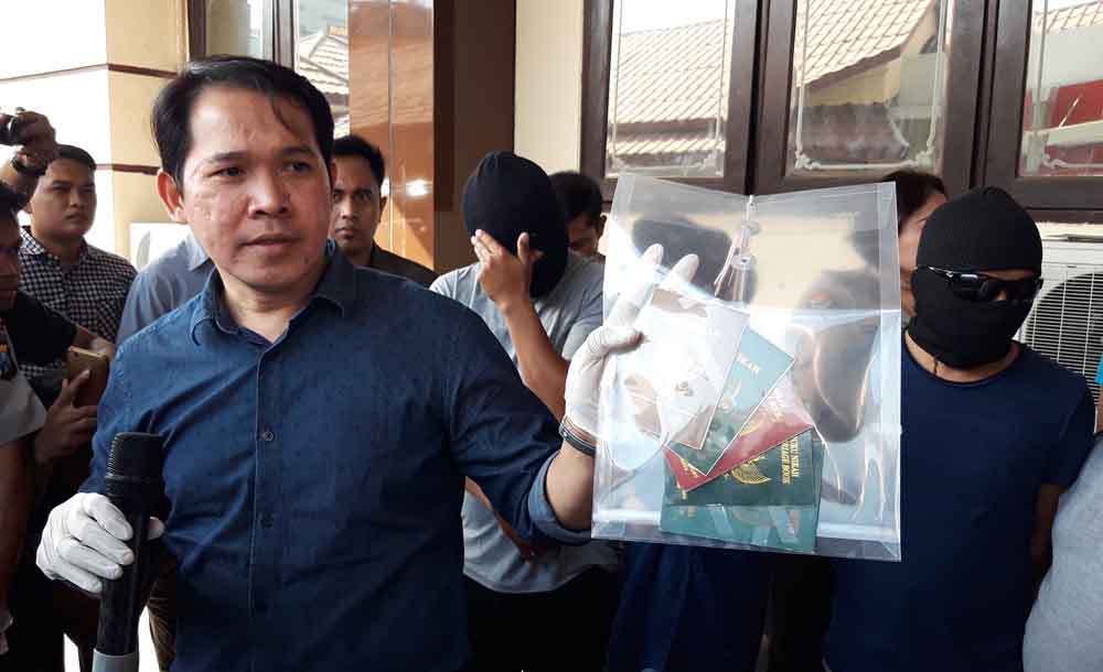Petugas menunjukkan barang bukti surat nikah pasangan swinger di Surabaya.